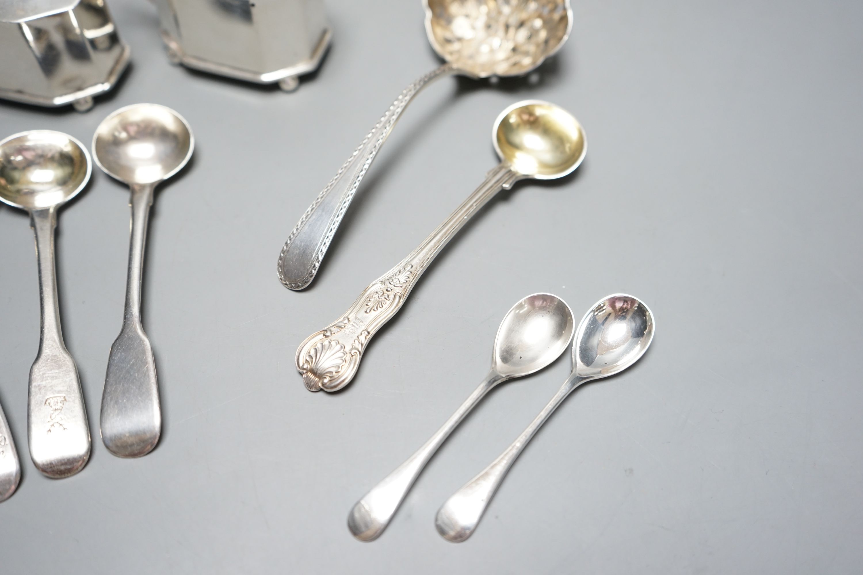 Seven assorted Georgian silver mustard ladles , a strainer, a pair of silver mustard pots and four spoons.